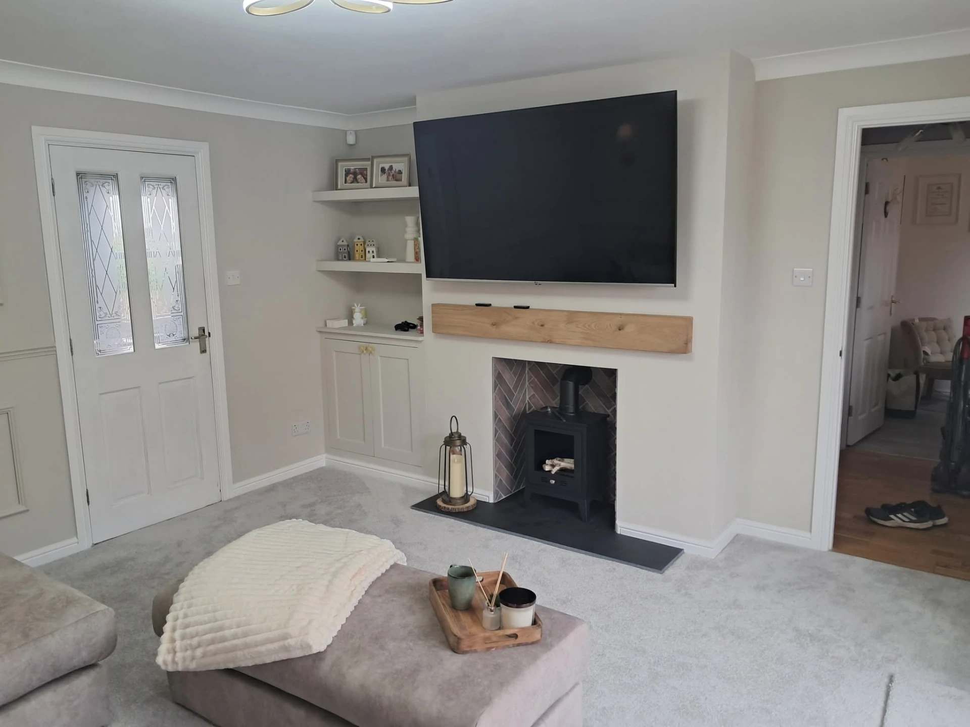 Fitted alcove units and oak mantel around a log burner